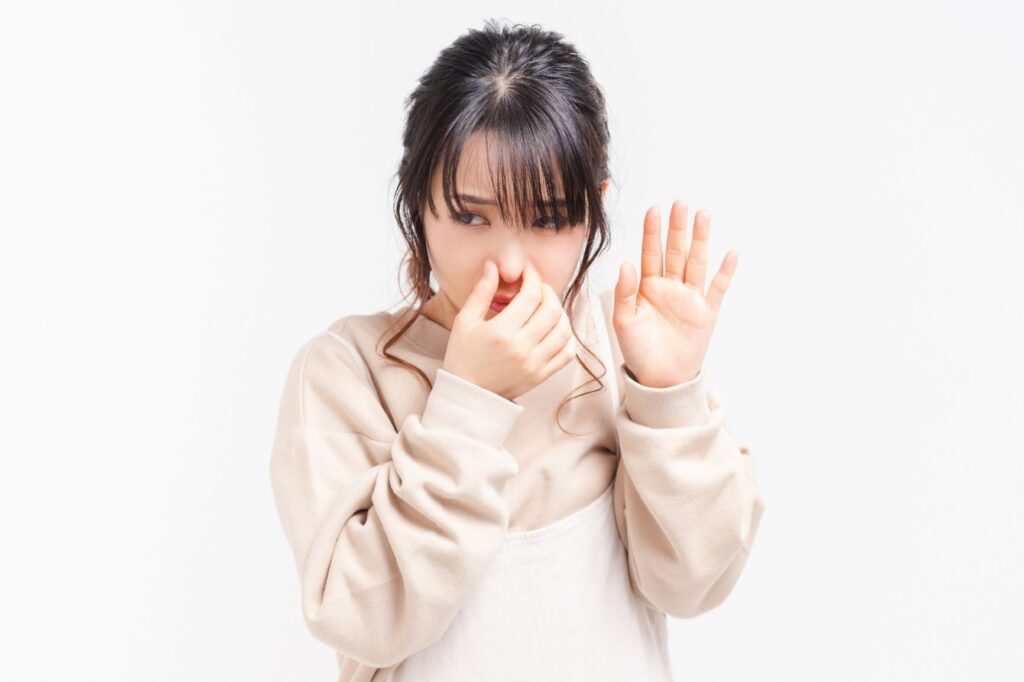 鼻をつまんで拒絶する女性
